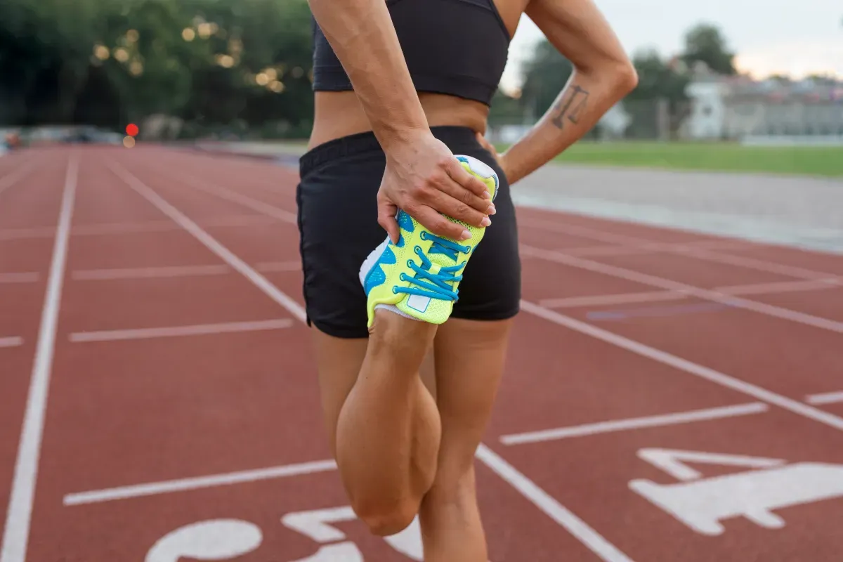 Runner on a trail holding their knee during a training run