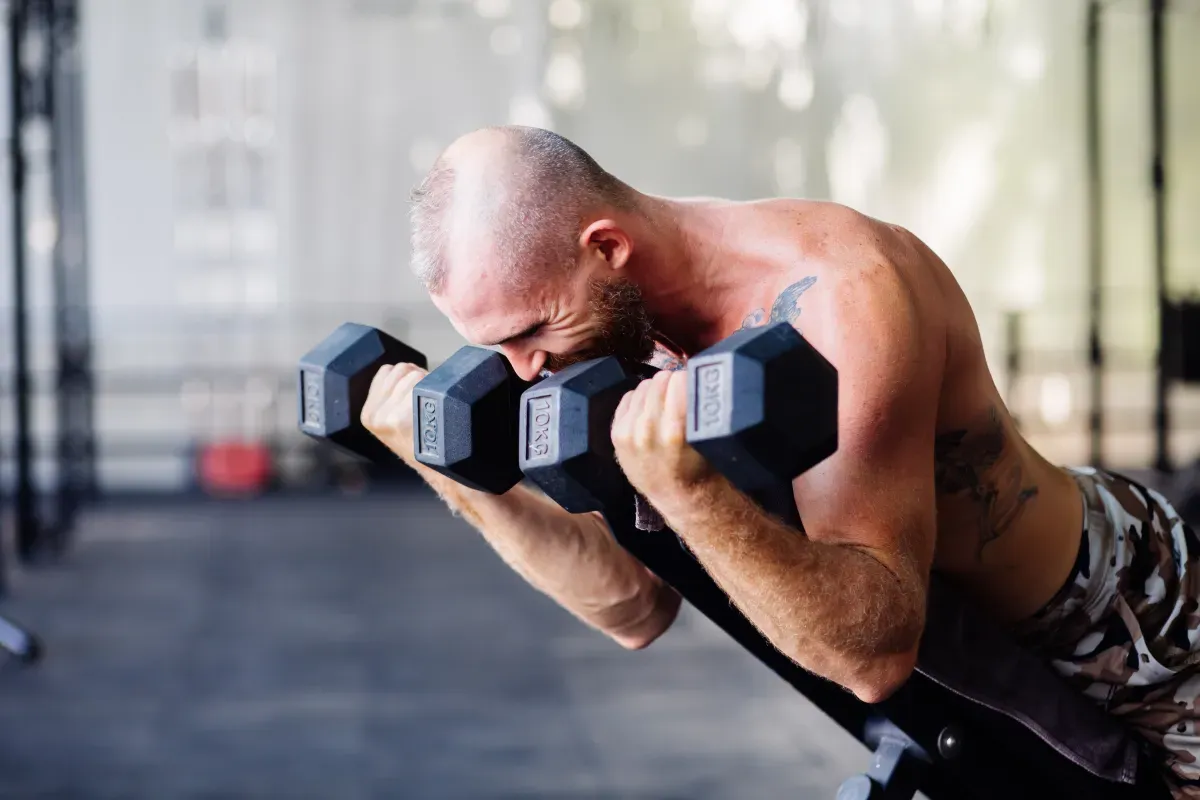 Person performing a squat with a barbell in a well-lit gym